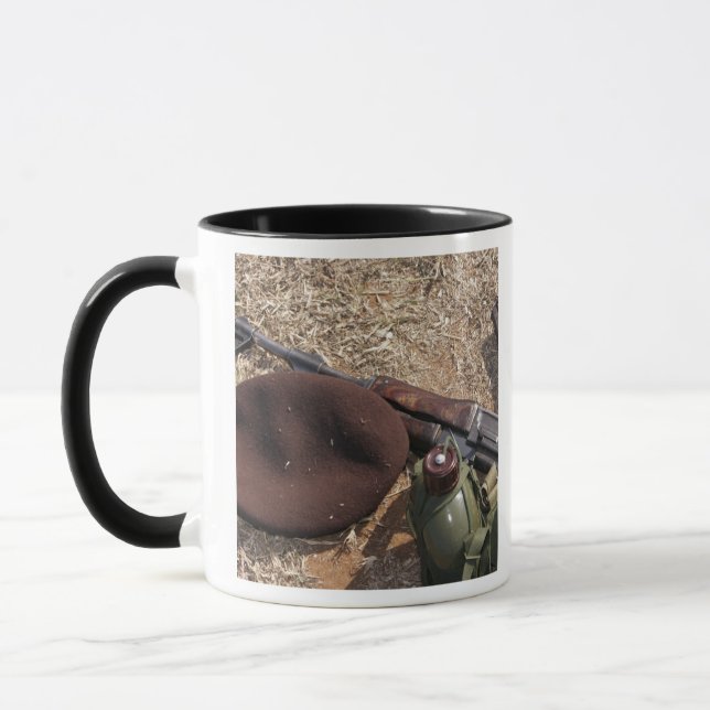 A rifle, military cover and canteen mug (Left)