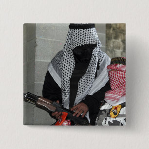 A role-playing enemy aggressor arms a dummy 2 inch square button