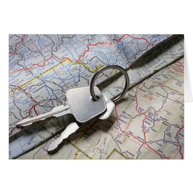 A set of car keys on a pile of road maps. (Front Horizontal)