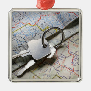 A set of car keys on a pile of road maps. metal ornament