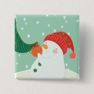 A snowman hanging an ornament on a tree 2 inch square button