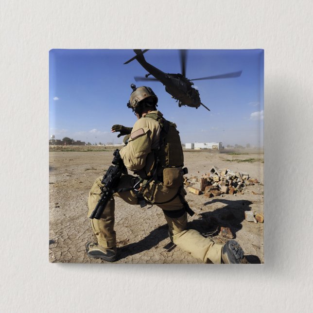 A soldier conducts security for an HH-60 2 Inch Square Button (Front)