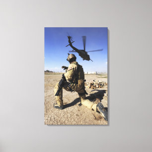 A soldier conducts security for an HH-60 Canvas Print