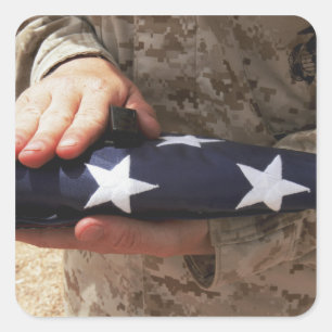 A soldier holds the United States flag Square Sticker