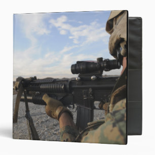 A soldier sights in to fire on a target binder