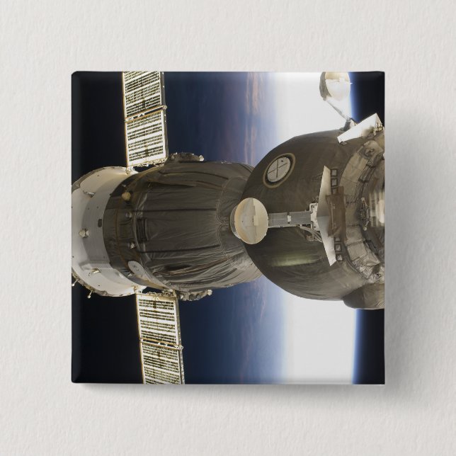 A Soyuz spacecraft backdropped by Earth 2 Inch Square Button (Front)