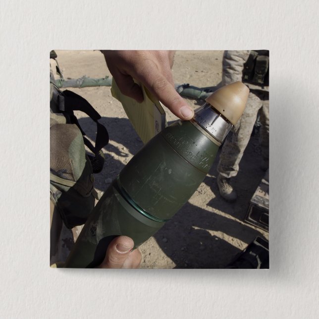 A squad leader points to a delay setting 2 inch square button (Front)