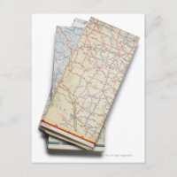 A stack of folded road maps on a white