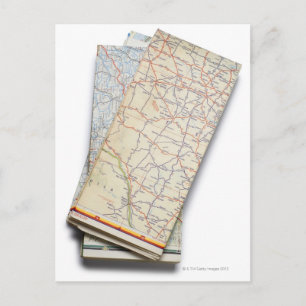 A stack of folded road maps on a white postcard