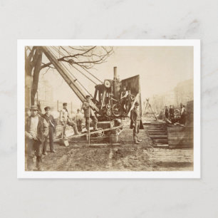 A steam crane in operation during the building of postcard