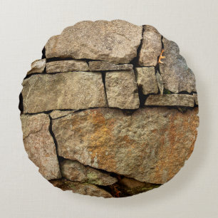 A stone wall made of cobblestones background textu round pillow