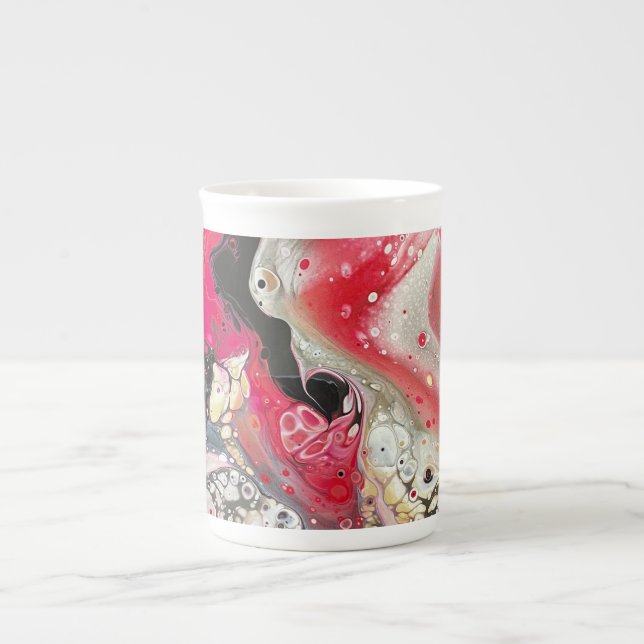 A tea or coffee mug with pink, gold, and black art (Front)