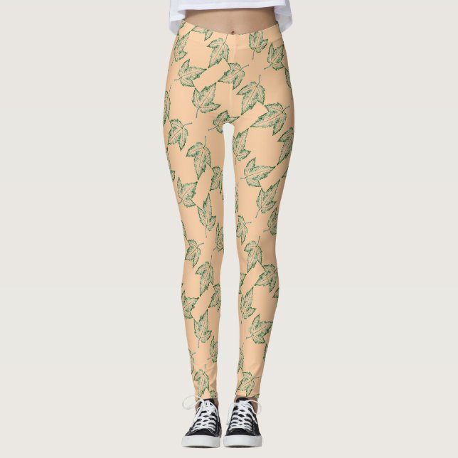 A tiled image of a maple leaf in green on buff leggings (Front)