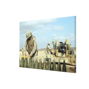 A US Marine prepares howitzer rounds to be fire Canvas Print