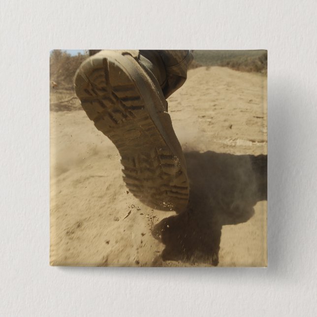 A US soldier walks along a dirt path 2 Inch Square Button (Front)