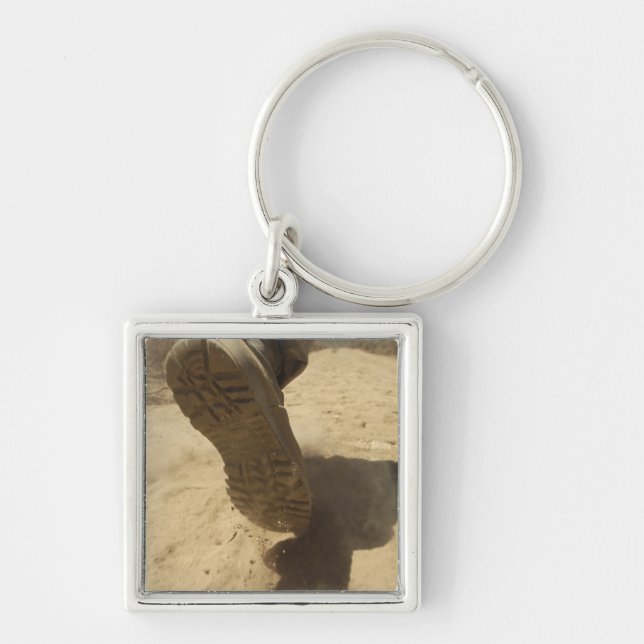 A US soldier walks along a dirt path Keychain (Front)