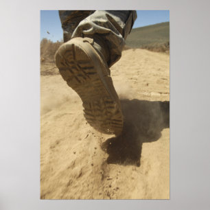 A US soldier walks along a dirt path Poster