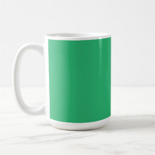 A vibrant green leaf with prominent veins and a de coffee mug