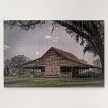 A weathered wooden barn surrounded by lush grass