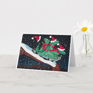 A whimsical holiday card with sledding dinosaurs
