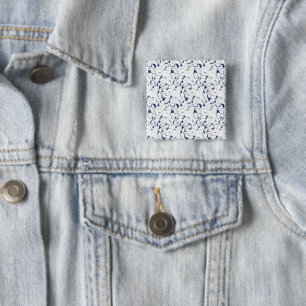 a white and blue background with a pattern 2 inch square button