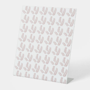 a white background with pink leaves on it pedestal sign