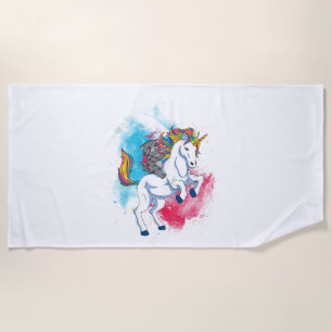A white unicorn with rainbow tail which is ridden beach towel