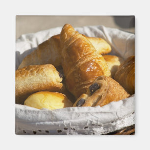 A wicker breakfast basket with croissants, and magnet