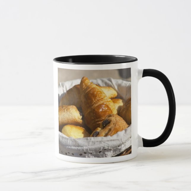 A wicker breakfast basket with croissants, and mug (Right)