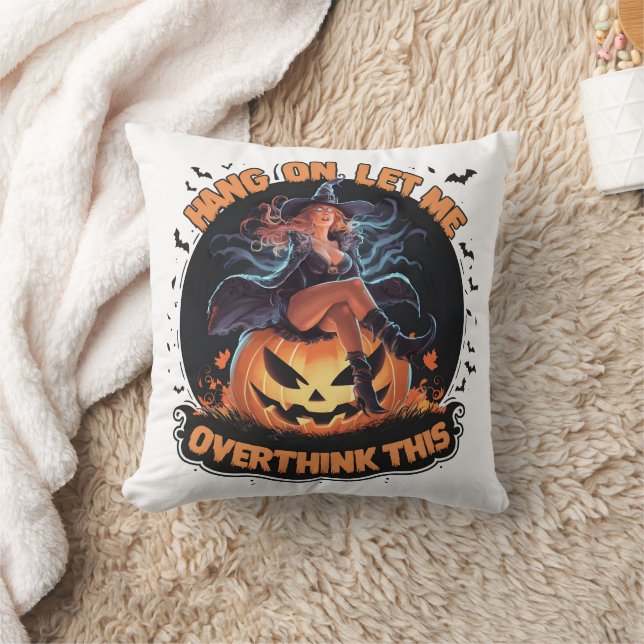 A witch playfully pondering atop a pumpkin throw pillow (Blanket)