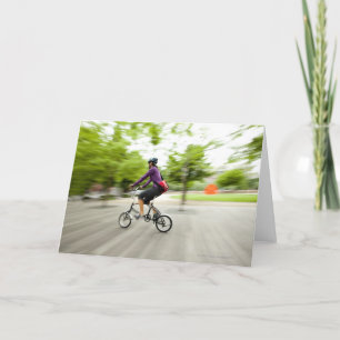 A woman using a folding bike to commute card