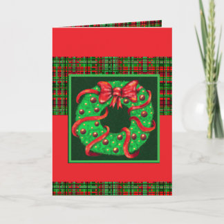 A wreath with a big red bow on plaid card