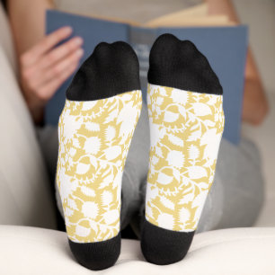 A yellow rug with a repeating motif pattern resemb socks