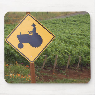 A yellow tractor crossing sign in the vineyard mouse pad
