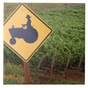 A yellow tractor crossing sign in the vineyard tile
