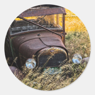 Abandoned old car in tall grass classic round sticker