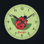 Adorable Red Ladybug Insect With Custom Name Round Clock<br><div class="desc">This clock has Destei's cartoon illustration of a cute red ladybug that has black spots on it. The background colour is light green and there is a personalizable text area for a name. The clock face is made of black numbers.</div>