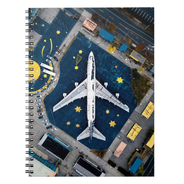 AERIAL PHOTOGRAPHY OF WHITE AND BLACK AIR LINER ON NOTEBOOK (Front)
