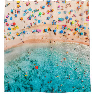 Aerial view of sandy beach with colourful umbrella