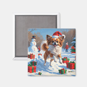 Aimant Chien Papillon courant dans la neige avec un chape