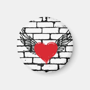 Aimant Coeur rouge avec ailes d'ange sur un mur de brique