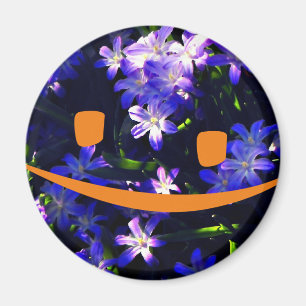 Aimant Le visage souriant jaune sur les fleurs bleues