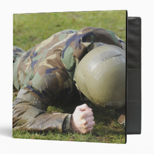 Airman crawls through a wet field binder