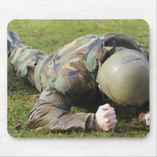 Airman crawls through a wet field mouse pad