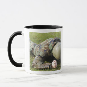 Airman crawls through a wet field mug
