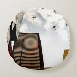 Airplanes flying over buildings round pillow