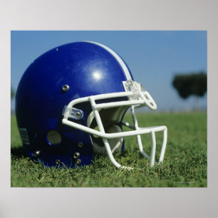 American football helmet in grass,close-up poster