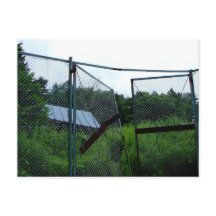 An abandoned house beyond the broken fence.
