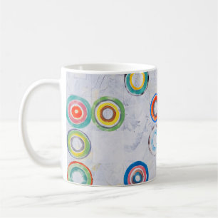 An abstract painting; multicolored circles on a gr coffee mug