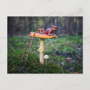 An acorn elf is resting on a mushroom postcard